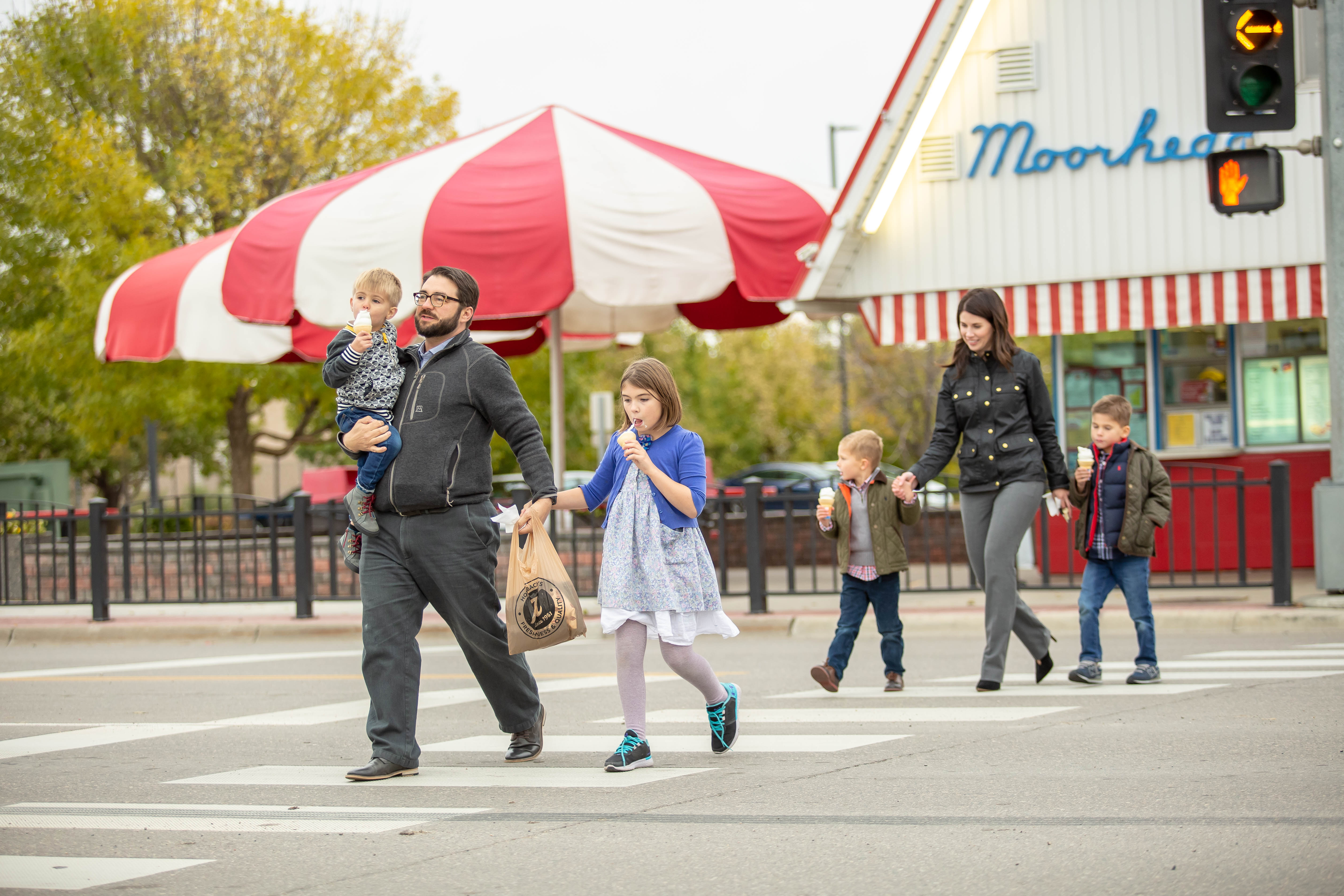 A family walks across the street holding hands
