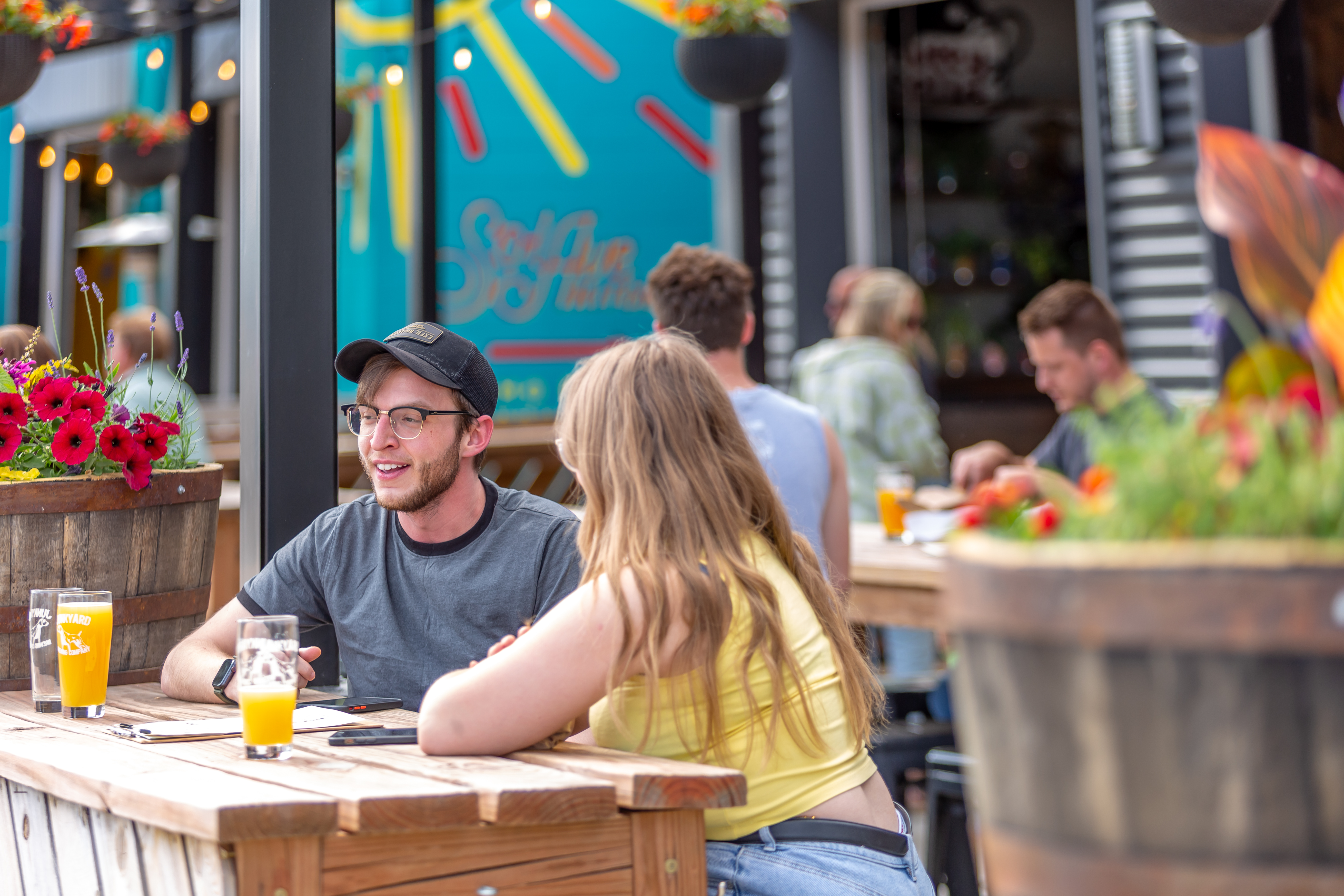 People sit next to each other at an outdoor bar area