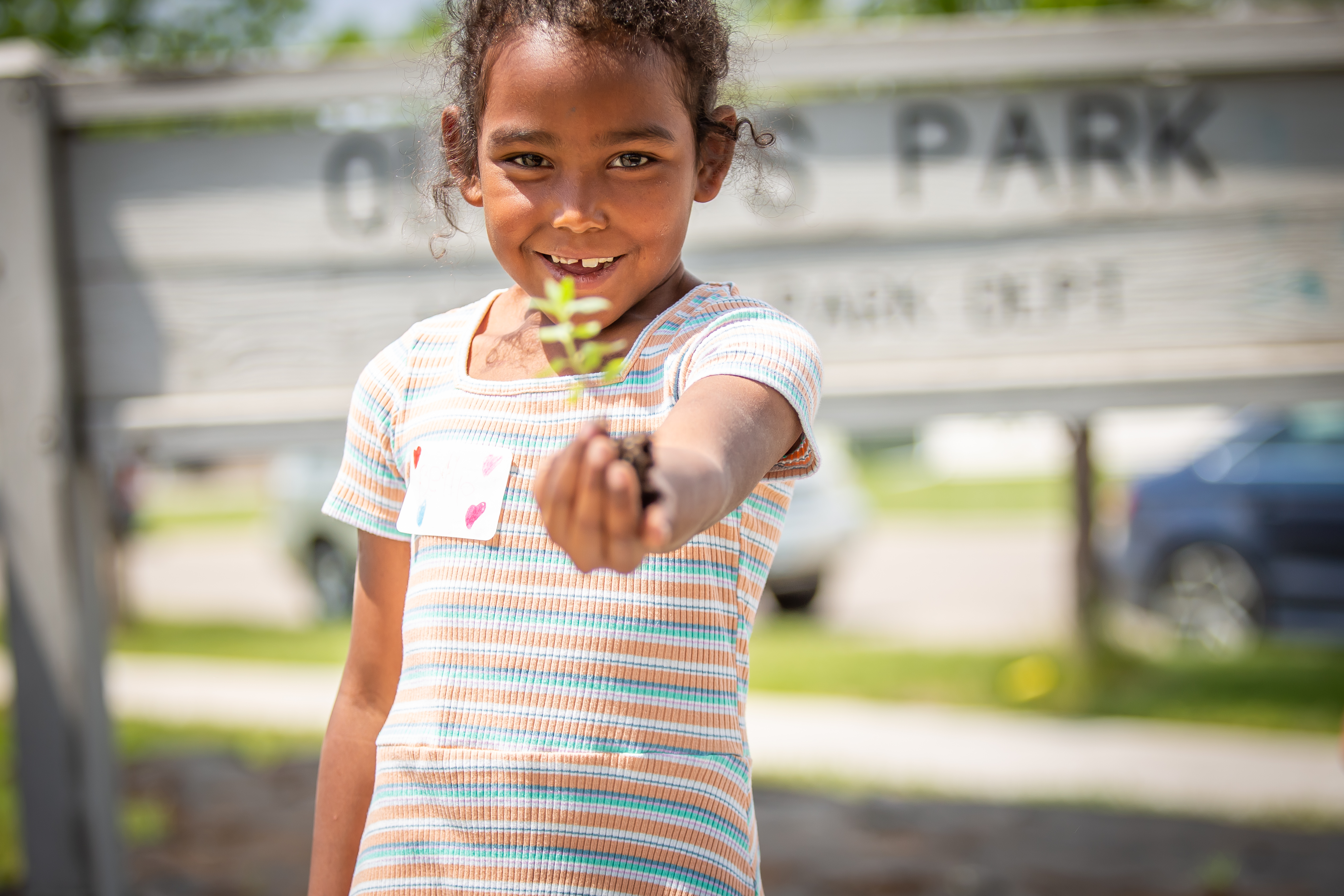 A girl holds a plant in her hand