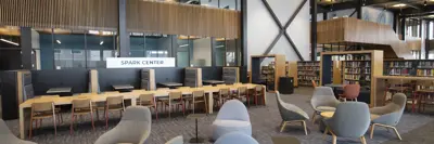 a view of the spark center in the loop - includes chairs and tables and a sign that says Spark Center