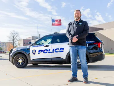 Mike is standing in front of a police car