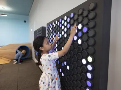 A child plays with the interactive light display in the children's play area.