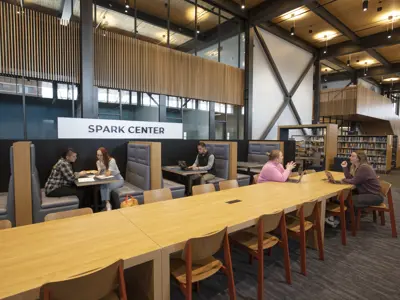 People sitting at a table in the Spark Center and having a conversation or meeting