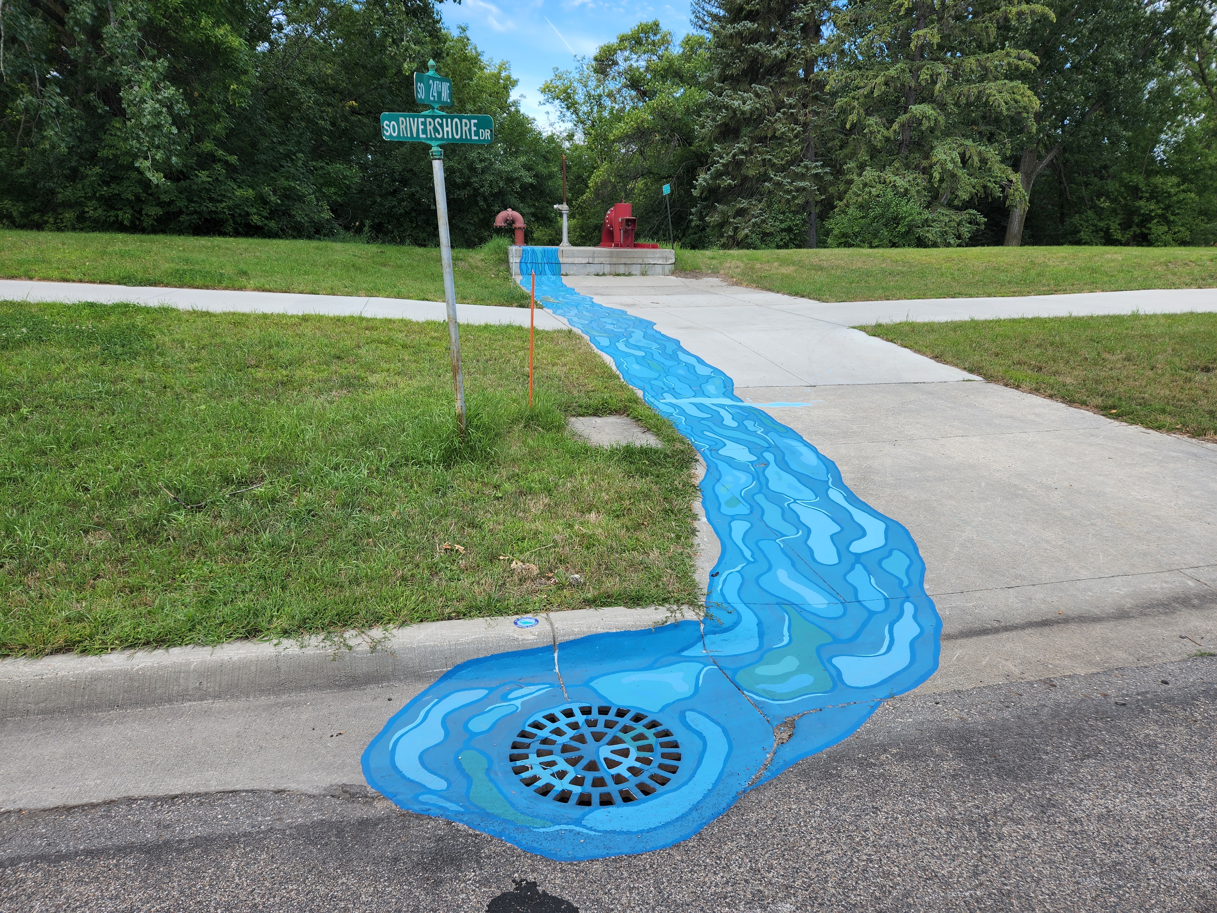 An image of drain art on the side of the road