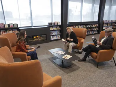 People sitting in orange chairs and talking 