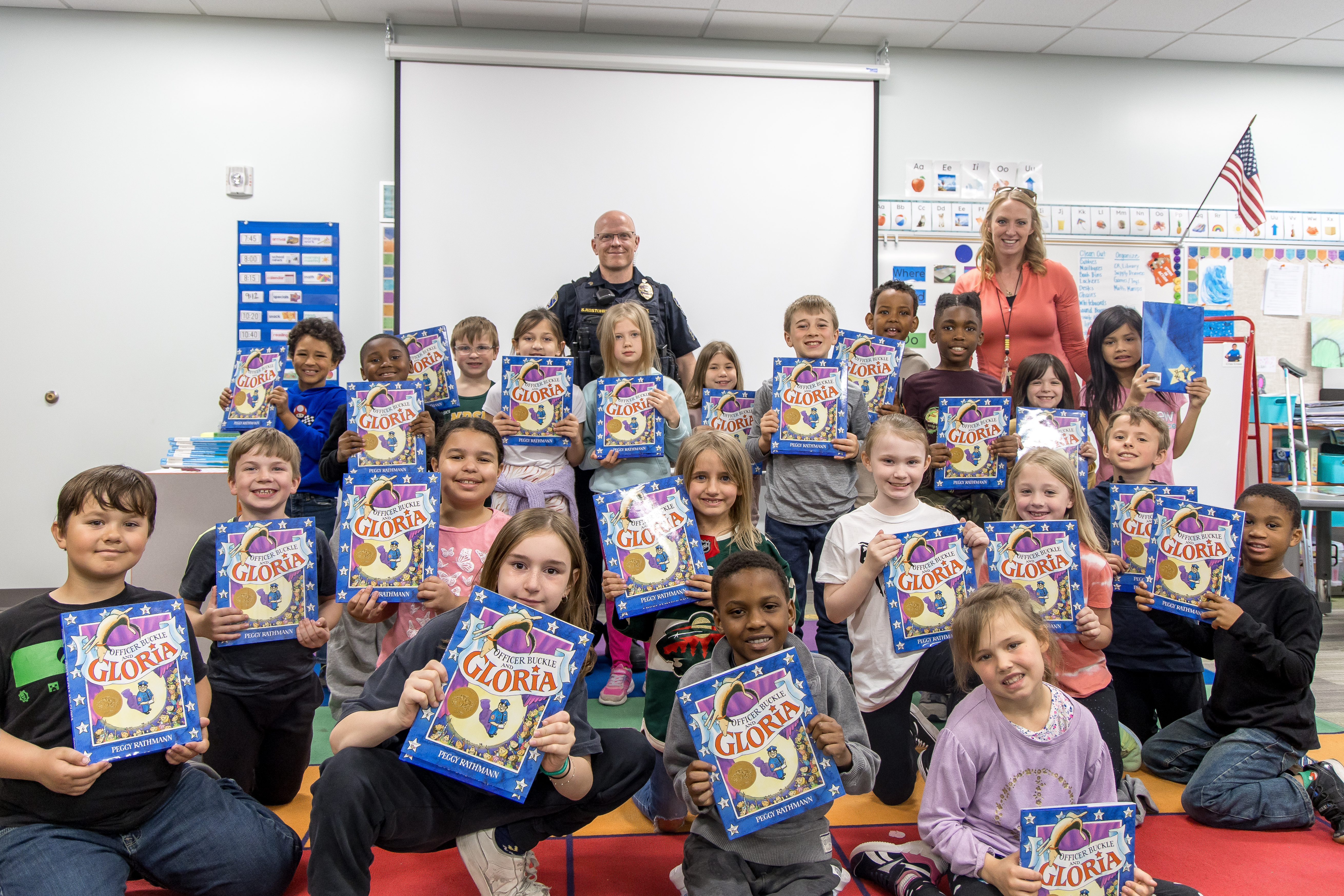 children hold books they received from the PAL book club in their classroom