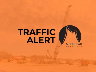 construction image with an orange hue and the words Traffic Alert and the City of Moorhead logo in black
