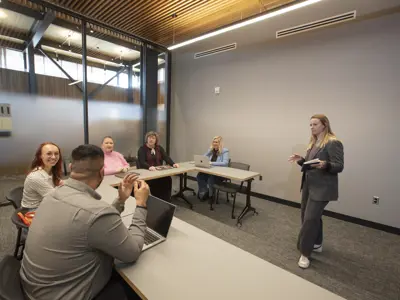 A presenter is meeting with people in the meeting room space