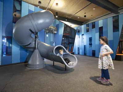 2 children playing on the slide at the indoor playground