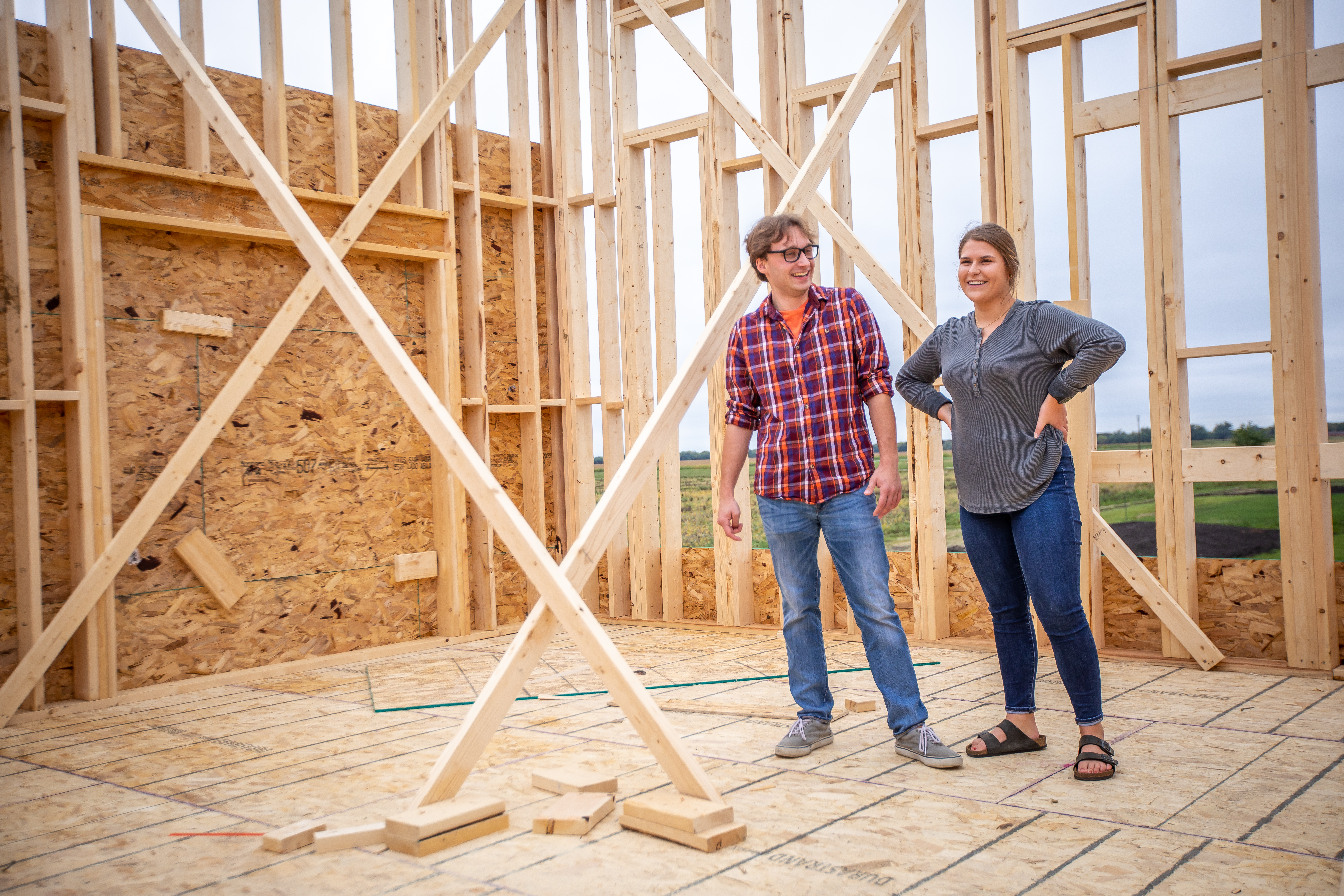 two homeowners stand in their house under construction
